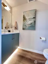 Main floor powder room with motion activated under cabinet lighting.