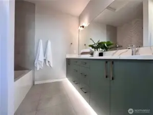 Upstairs full bath with double vanity and tub/shower combo, motion activated under cabinet lighting.