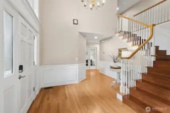 Another entry photo showing the hardwoods, stairwell and the bedroom/office towards the back.