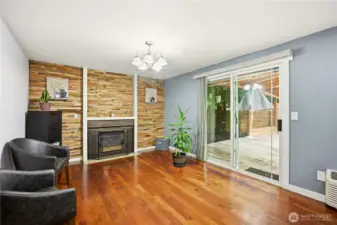 Cozy secondary living space featuring a classic brick fireplace and easy patio access.
