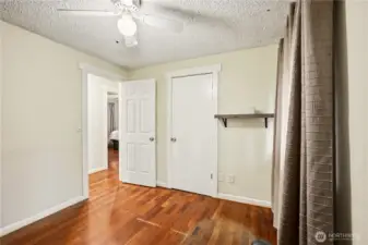 Another view of the versatile third bedroom, showcasing the warm engineered wood flooring.