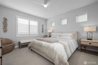 Primary bedroom with transom windows, black out shade, and plantation shutters