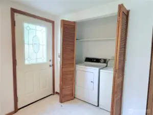 Older working washer and dryer by back door