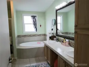 A View of the 5 Piece Primary Master Bathroom Showing Tile Counter Top, Tile Floor, and Tile Soaking Tub Surround.