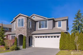 Front of home with arched stone-accent entry.