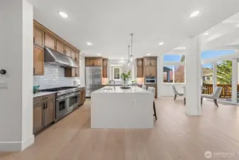 Kitchen has large island with waterfall slab countertop.