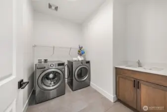 Spacious laundry room with sink on upper level.