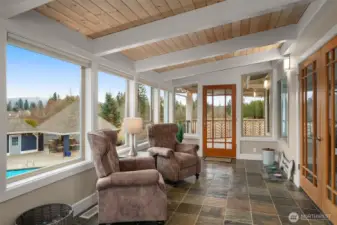Light-filled sunroom off the primary suite with views of the surrounding landscape.