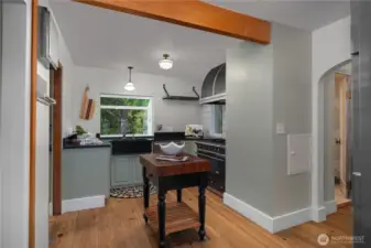 Rich wood flooring, soapstone counters and sink, and a professional-grade gas range/dual fuel oven bring timeless function to this beautifully maintained kitchen.