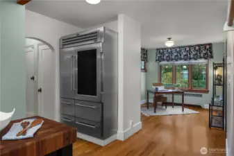 The oversized refrigerator and adjoining workspace add everyday practicality while preserving the home’s timeless appeal.