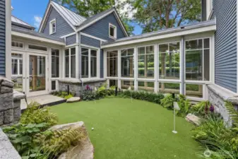 Putting green in courtyard surrounded by hallways and rooms in home