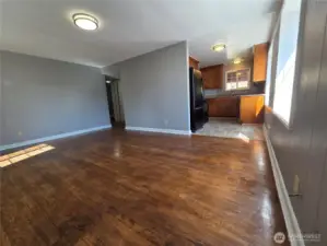 Upstairs unit at front door looking into living room and towards kitchen. Nice original hardwood floors