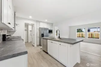 Through the doorway to the left of the fridge is a pantry space and laundry room.