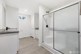 Primary bath with dual vanities and walk in shower with bench.