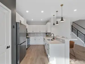 Well appointed kitchen with ample cabinets, quartz counters and stainless steel appliances.