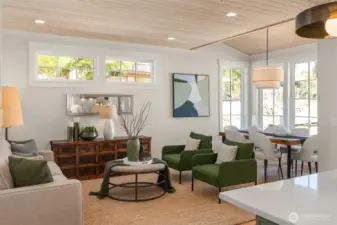 The light filled living room is surrounded by windows to let in light.