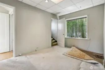 This room has been used as an office.  Appears to be original Marmoleum under carpets. Stairs go to upper bedrooms.