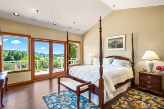 Primary bedroom with French doors, scenic view and vaulted ceilings