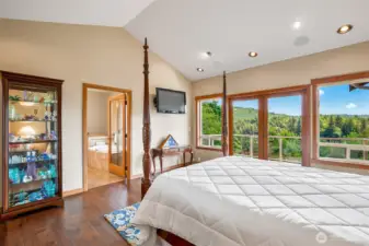 Primary bedroom with French doors, scenic view and vaulted ceilings