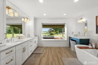 Tastefully remodeled primary bathroom: New vanities, tile flooring, bathtub, light fixtures, mirrors, tile shower and reconfigured layout.