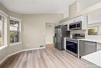 Fully updated kitchen featuring brand-new stainless-steel appliances, white shaker cabinets, and solid-surface countertops. Modern design with high ceilings, neutral tones, and plenty of natural light.