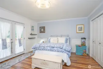 Primary suite with access to a private deck through elegant French doors.