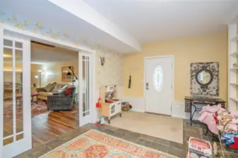 Lower-level entry into an additional finished room with pocket doors opening to the family room.