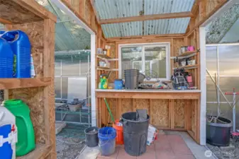 Convenient work space between the greenhouses for gardening projects.