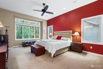 The spacious primary bedroom looks out over the forest views and because the house sits above the trail, it's extremely private.