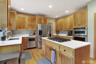 Kitchen with quartz countertops, spanish ceramic tile backsplash, 5 burner gas top and SS appliances.