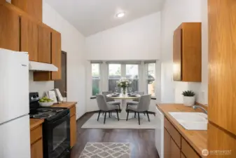 Virtually staged kitchen & dining room with bay window.