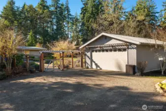 Two-car detached garage/studio with gravel garden entrance on left. Ample parking inside or outside the garage.