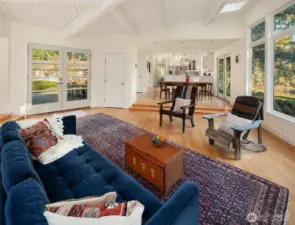 Looking up into dining area with kitchen beyond. Door to primary suite is beyond kitchen.