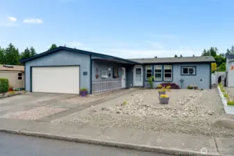 Charming front exterior with zero-maintenance yard, 2-car garage, and welcoming entry in the gated 55+ Thunderbird Village.