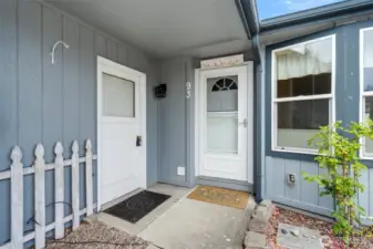 Inviting covered front porch with easy-care landscaping and private entry door.