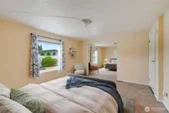 Primary suite with a generous mirrored closet to keep everything organized, plus a large window that fills the room with natural light. (Virtually staged)