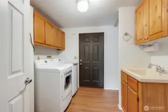 Convenient utility room with washer, dryer, utility sink, and extra storage to keep things tidy.
