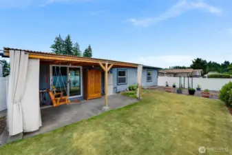 Fully fenced w/easy maintenance vinyl fencing--private backyard with a covered patio and lush lawn, ready for quiet mornings or casual gatherings.