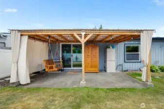 Covered patio with a cozy swing—perfect for sipping coffee, reading a book, or enjoying peaceful afternoons.