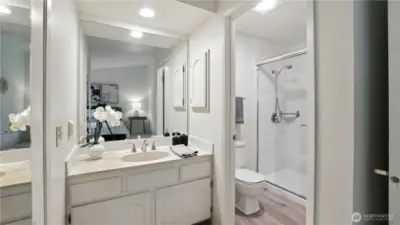 Nestled inside the primary bedroom and refreshed with all new recessed lighting, this ensuite bathroom features sleek countertops, abundant mirrors, and a separate toilet and walk-in shower, combining style and functionality