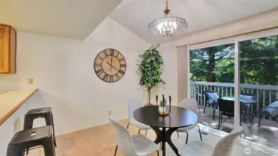A grand sliding glass door and vaulted ceilings create a sophisticated, light-filled dining space with timeless design