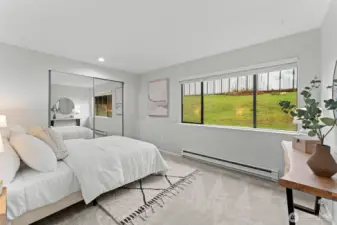 Generously sized primary bedroom with plush carpeting and a soothing neutral palette. Mirrored closet doors reflect natural light and enhance the open feel, while the well-proportioned layout easily accommodates a king-size bed, creating a peaceful and inviting retreat.