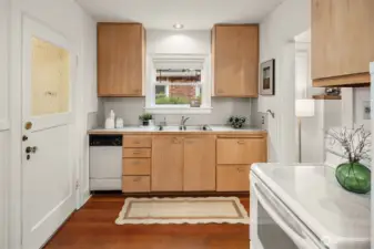 Charming kitchen detailing clean finishes and flat-panel wood cabinetry.