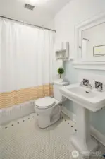 The upstairs bathroom features honeycomb tile—a charming ode to the home’s era.