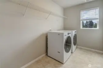 Oversized laundry room with wire shelving and washer and dryer included.