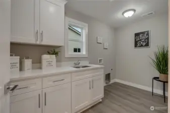 Convenient upstairs laundry with storage  cabinets & sink