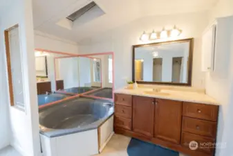 Large soaking tub in the primary bedroom with vanity.