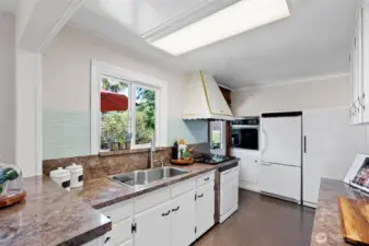 Kitchen view and easy door out to serving on the back deck and to upper garden area.