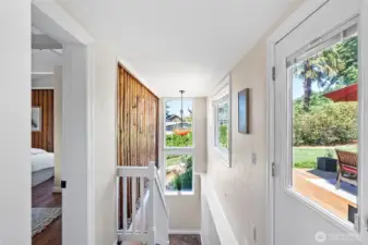 Internal stairs lead down to the main entry. There are so many possibilities for coming and going. Enter from the top level or from below. Currently the main entry is below, but the side door here could easily take one down to the parking allowing the lower level to be closed off.