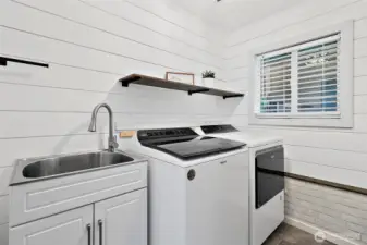 Farmhouse laundry room with utility sink and additional storage.